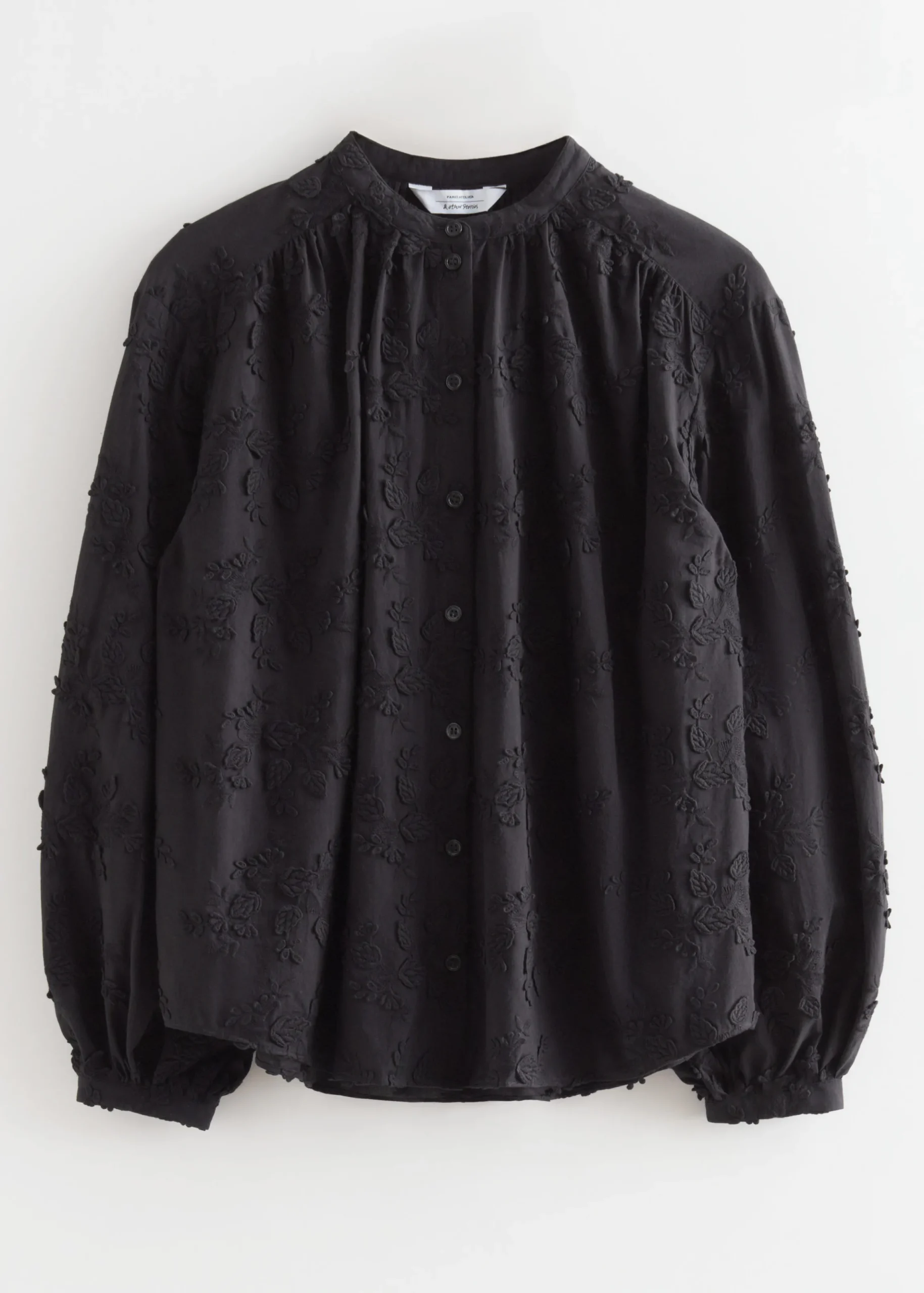 Voluminöse Bluse mit Blumenapplikation